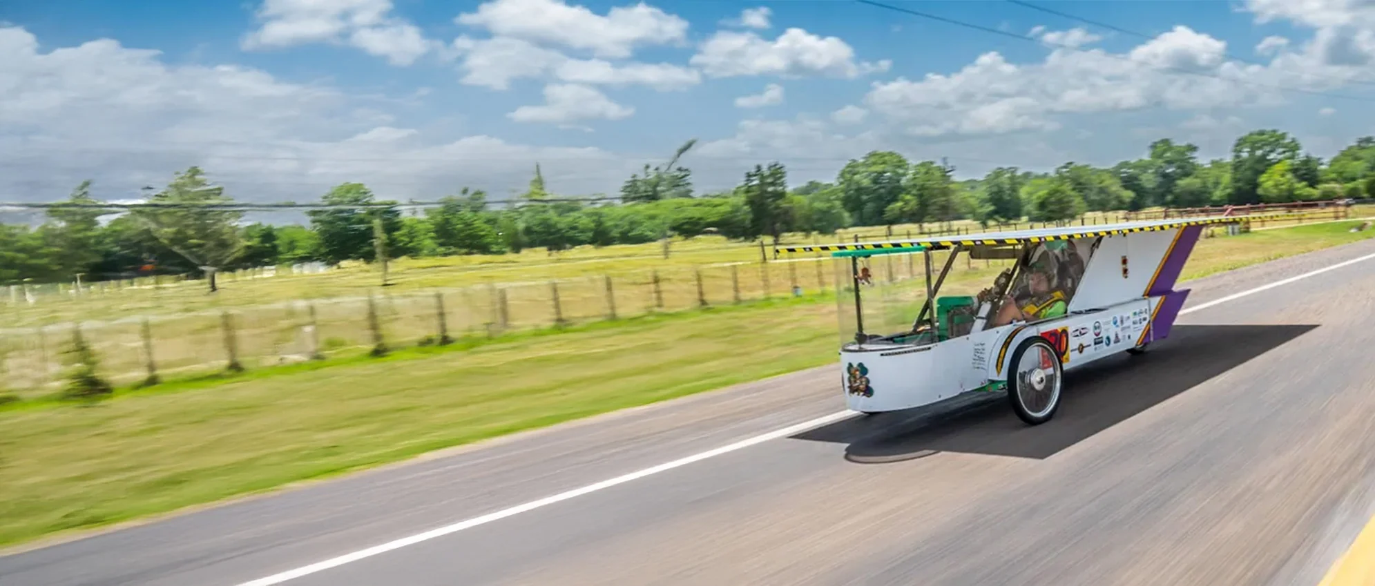 ALSET Paladins solar race car traveling along a tree-lined road