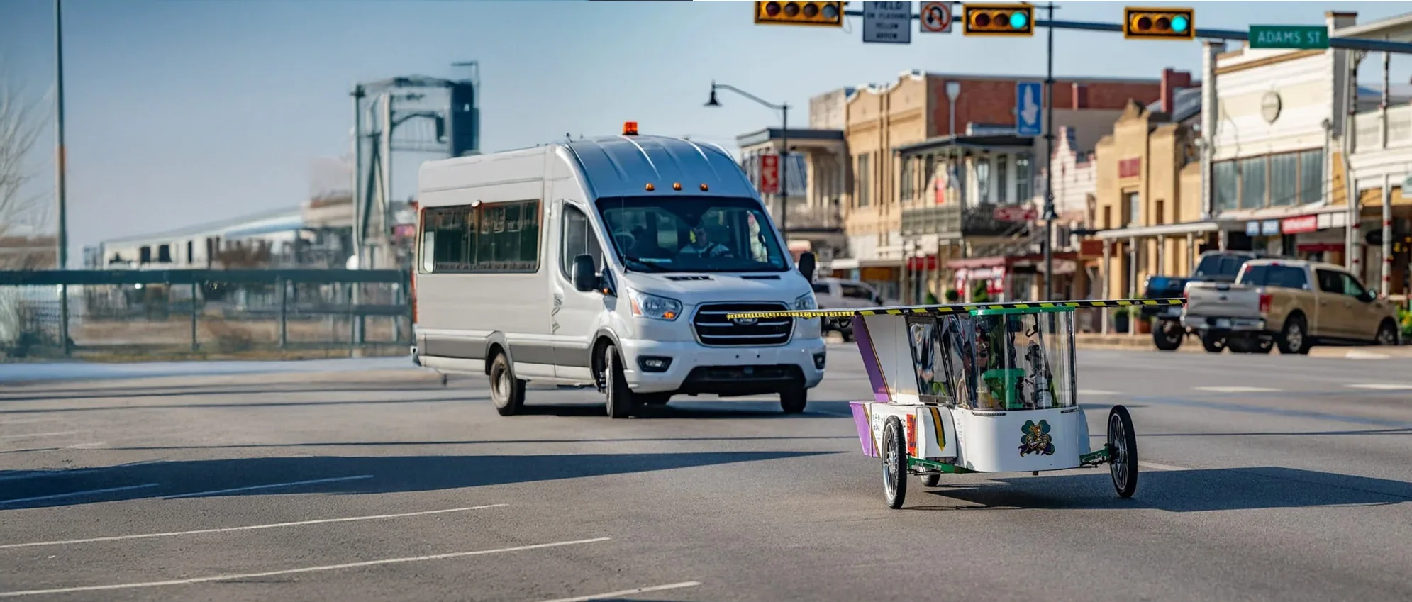 ALSET Paladins solar race car driving through a Texas town with the support vehicle