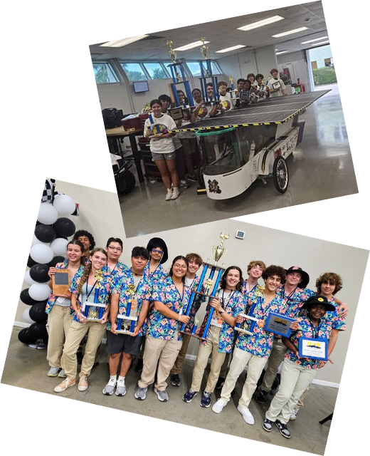 Team members standing next to their solar car and championship trophies